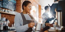 woman making coffee in shop